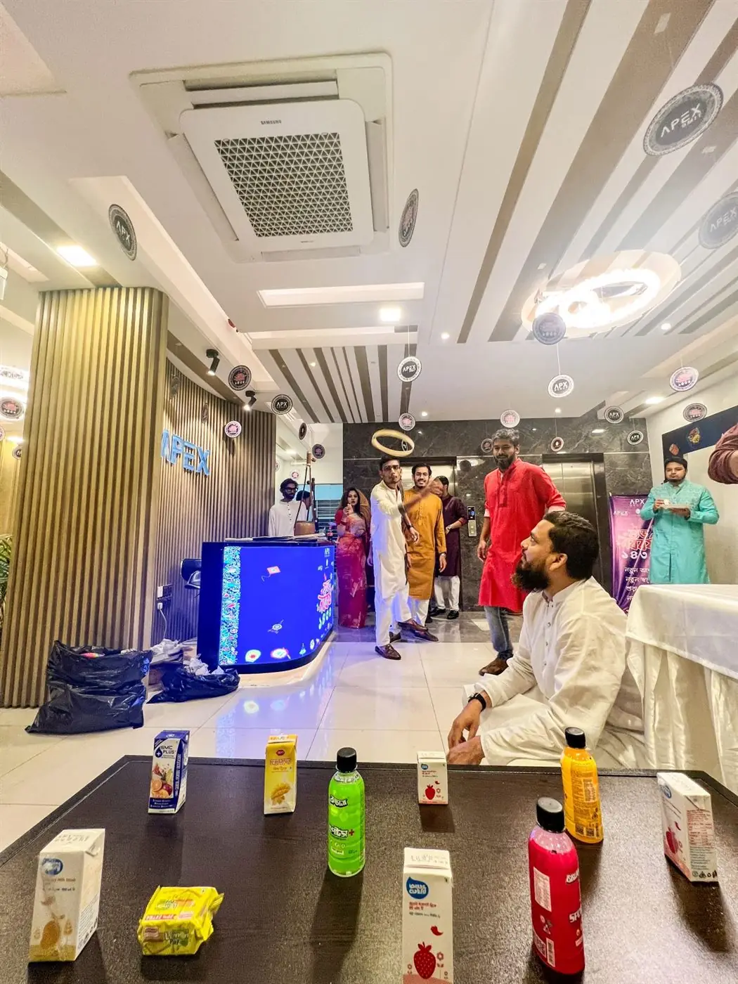 Team members in traditional dress at an office event beside the reception
