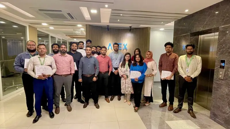 Apex DMIT team members holding certificates in the office lobby
